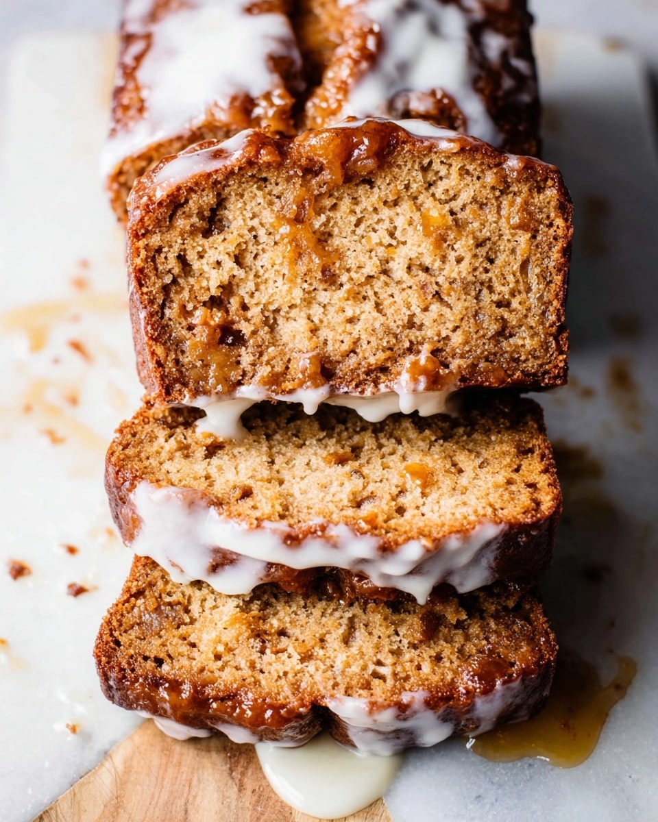 Three slices of moist, golden-brown bread stacked on each other with a shiny, sticky glaze dripping down the sides. The top slice has a darker caramelized crust, while the inner texture looks soft with small fruit pieces embedded inside. The bread rests on a white marbled surface with some glaze pooling around it, giving a fresh, homemade look. photo taken with an iphone --ar 4:5 --v 7