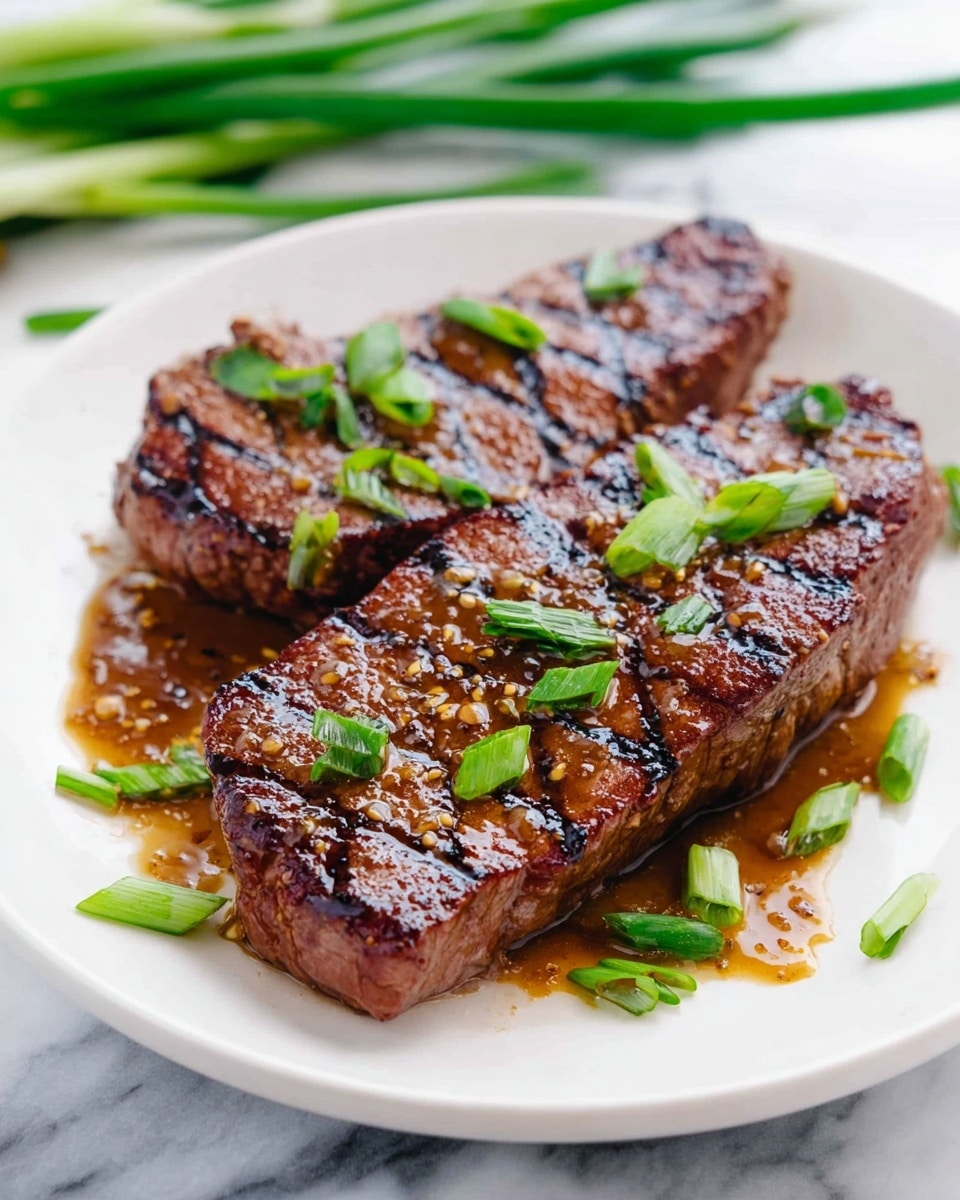 A white plate holds two grilled steaks placed side by side, each with dark brown sear marks running diagonally across the top. The steaks have a juicy, glossy surface with a light brown sauce spread over them, adding a shiny texture. Scattered green onion slices decorate the steaks and the surrounding plate, providing pops of green color against the meat and white plate. The background features a white marbled surface with some fresh green onion stalks blurred in the background. Photo taken with an iphone --ar 4:5 --v 7