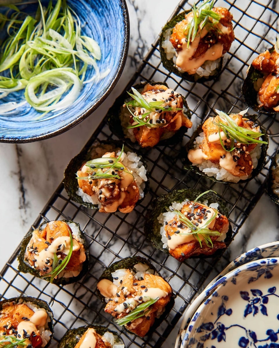 The image shows small sushi cups arranged on a dark wire grid over a white marbled surface. Each sushi cup has three layers: the bottom layer is dark green seaweed shaped like a cup, filled with white sushi rice as the middle layer, topped with pieces of orange-brown cooked fish, some with creamy light beige sauce drizzled, and garnished with thin green scallion strips and black and white sesame seeds. To the left, part of a blue-rimmed bowl with thin green scallions inside is visible, and on the right, part of a white plate with pawns in a blue pattern peeks into the frame. Photo taken with an iphone --ar 4:5 --v 7