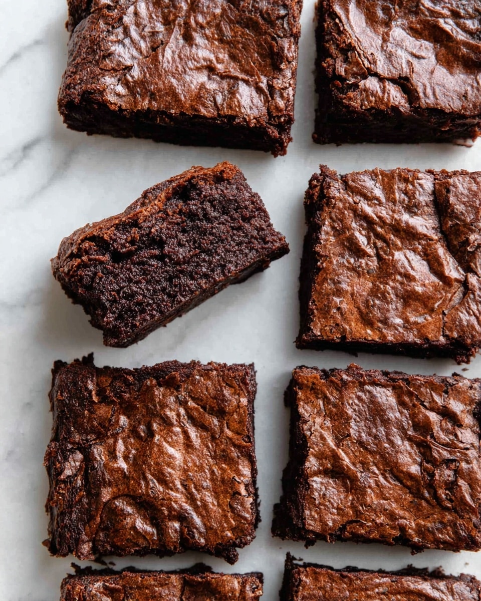 Nine thick square brownie pieces are arranged neatly on a white marbled surface, each piece showing a dark brown, slightly rough and textured top layer. One brownie piece is slightly lifted and tilted, revealing a dense, moist, and crumbly inside with a rich chocolate color. The surface of the brownies has wrinkles and small cracks, giving a homemade look. photo taken with an iphone --ar 4:5 --v 7