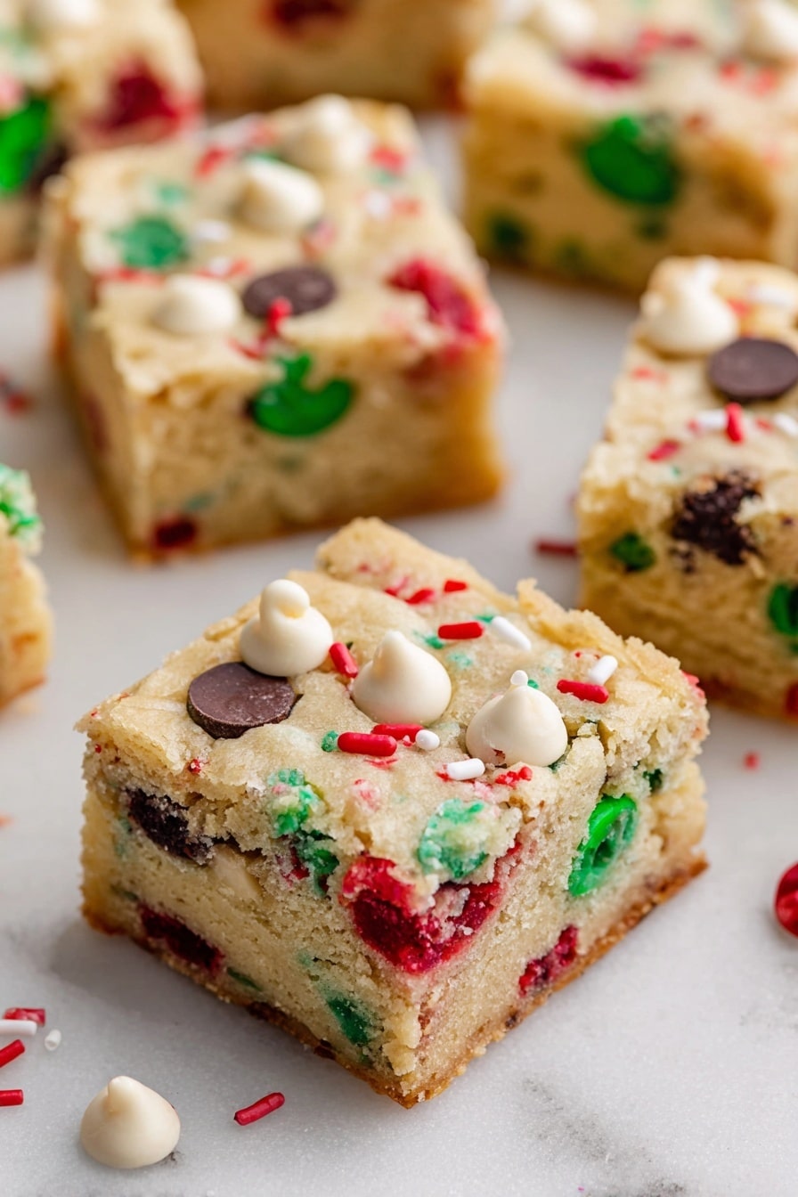 Christmas Cookie Bars, festive cookie bars, holiday bar cookies, easy Christmas desserts, Christmas baking ideas - The image shows square pieces of soft, light-colored cookie bars spread out on a white marbled surface. Each bar has two layers: a thick, slightly crumbly beige cookie base studded with colorful red and green candy pieces, along with dark and white chocolate chips scattered evenly throughout. The top layer is the same cookie dough with visible embedded candy and chips, giving a festive look. Small white and red sprinkles are also scattered on the surface of the bars. Photo taken with an iphone --ar 2:3 --v 7