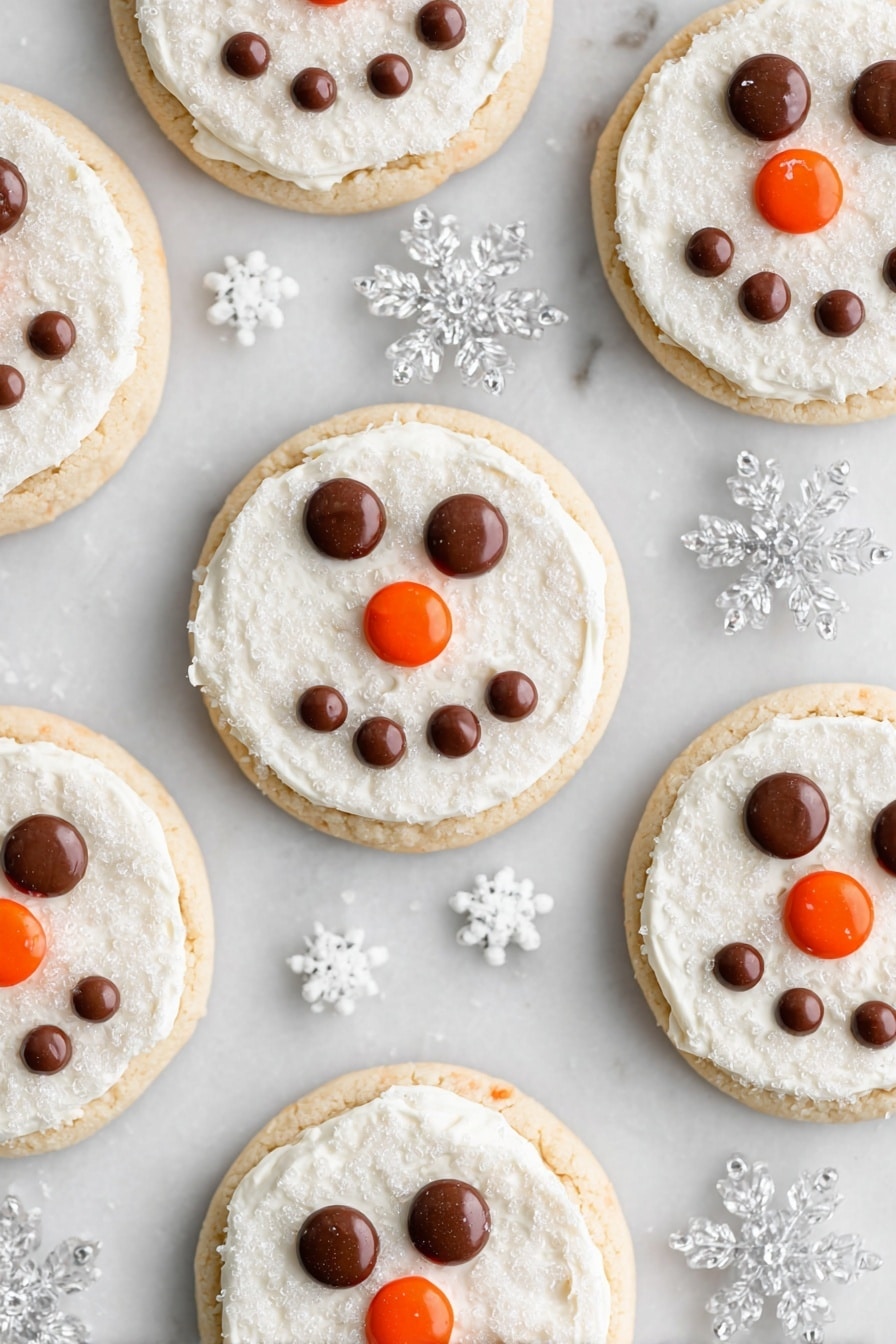 Snowman Face Cookies, festive holiday cookies, cute Christmas cookies, easy holiday cookie decorating, soft cake-like cookies - Several round cookies are arranged on a white marbled surface, each having two layers: a light golden cookie base and a thick, even layer of white frosting with a sugar crystal texture on top. On every cookie, chocolate candies form two eyes and a smiling mouth shape, while an orange candy is placed at the center to represent a nose. Clear plastic snowflake decorations and tiny white snowflake sprinkles are scattered around the cookies, enhancing the wintry theme. photo taken with an iphone --ar 2:3 --v 7