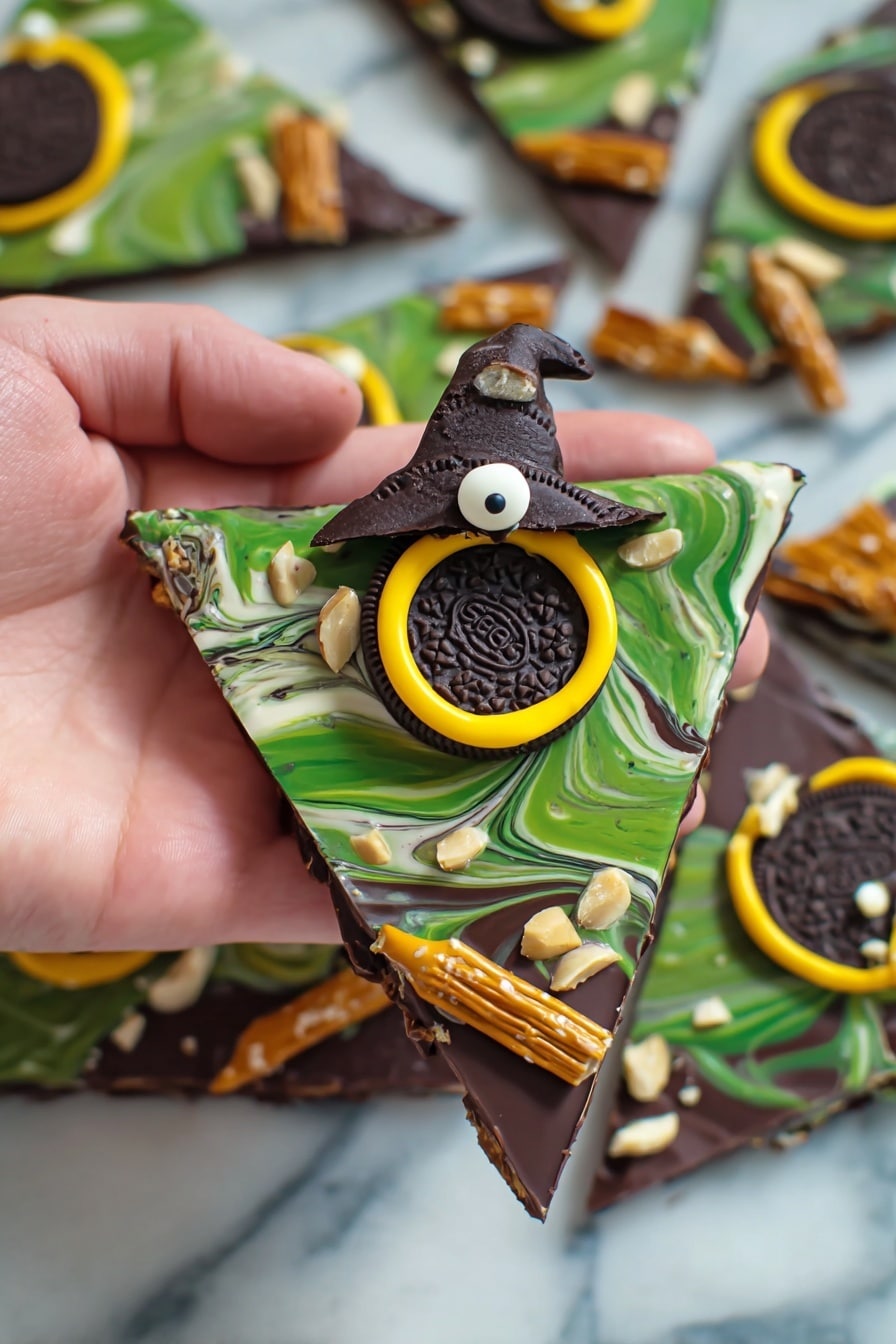 Melted Witch Halloween Bark, Halloween bark, spooky chocolate treats, Halloween candy bark, witch themed Halloween dessert - The image shows a hand holding a triangular piece of chocolate bark with three visible layers. The bottom layer is solid dark chocolate with a smooth finish. The middle layer is a swirl of green and white chocolate, creating a marbled effect. On top, there is a decorated Oreo cookie with a small chocolate witch hat in the center, outlined with a bright yellow ring of icing. Around the bark, there are small white candy eyes and slivers of white nuts scattered. The piece is finished with pretzel sticks dipped in chocolate placed diagonally at the edges, creating a broomstick look. The background is a white marbled surface with more similar chocolate bark pieces nearby. Photo taken with an iphone --ar 2:3 --v 7