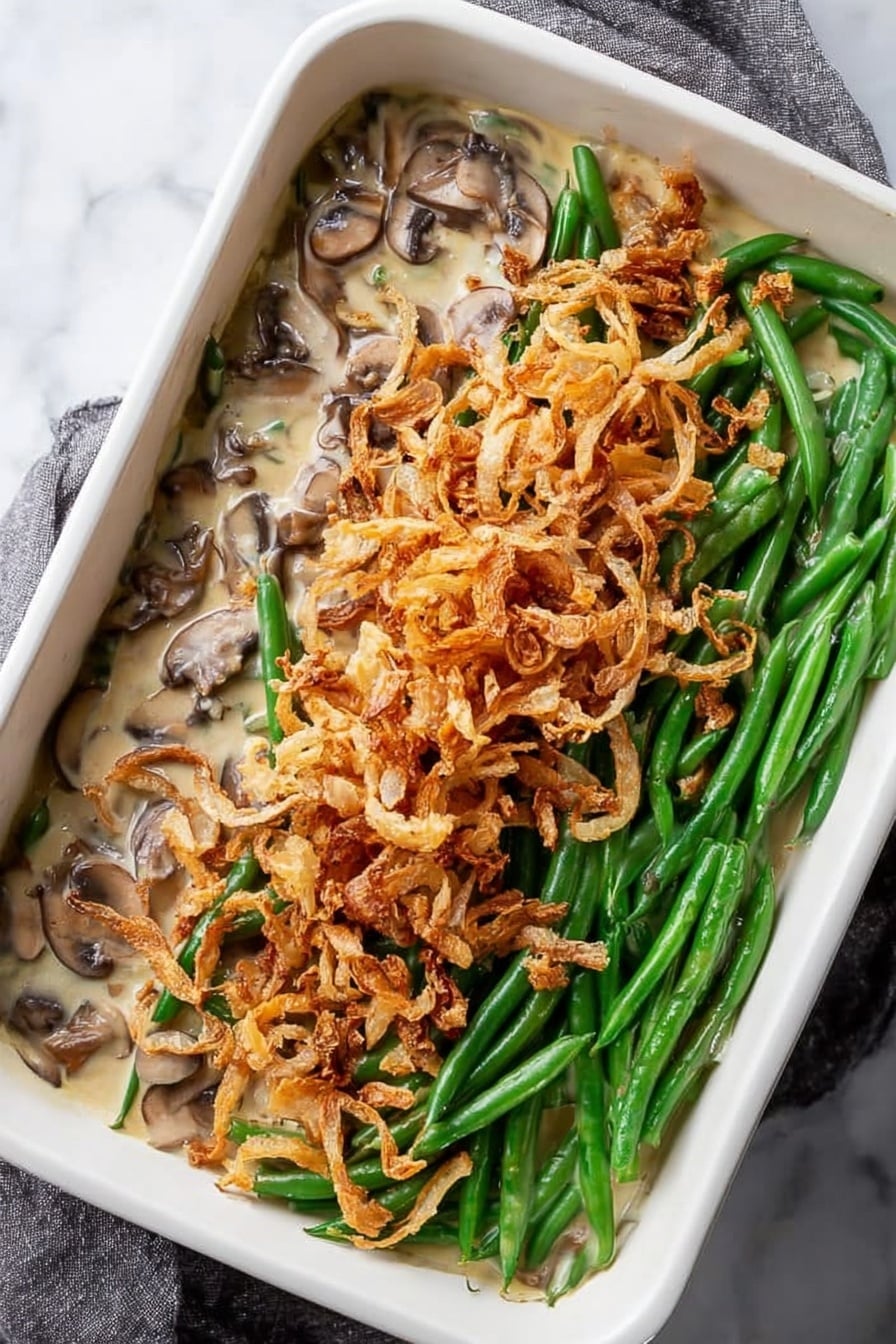 Green Bean Casserole with Cremini Mushrooms and Crispy Onions, healthy green bean casserole, homemade green bean casserole, mushroom green bean bake, festive vegetable side dish - A white square tray filled with a single thin layer of crispy fried onion strings, showing a mix of pale golden and light brown colors, some pieces are curled and others are straight, with slight dark brown edges indicating toasted spots. The texture looks crunchy and scattered unevenly across the tray, resting on a white marbled surface. Photo taken with an iphone --ar 2:3 --v 7