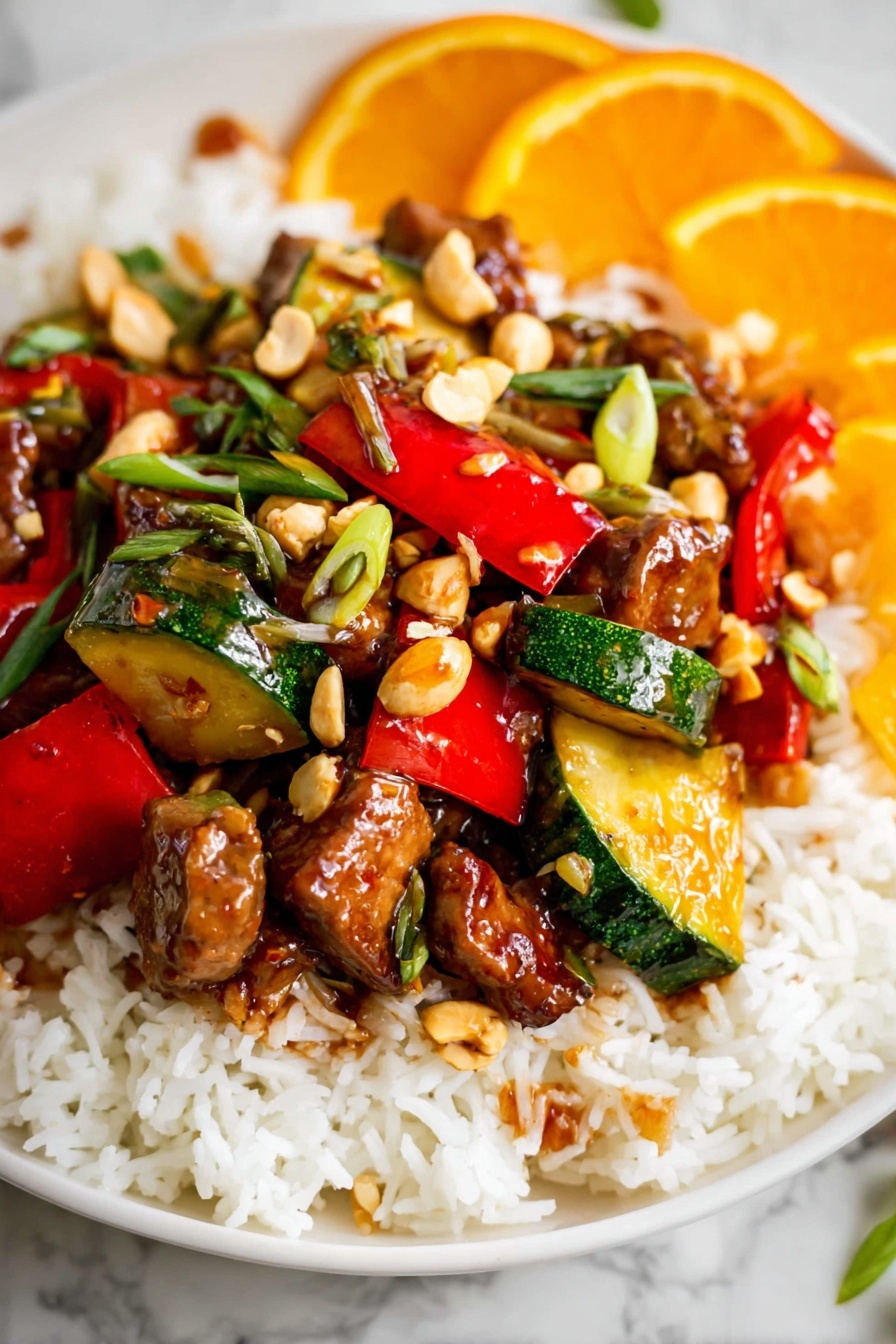 Kung Pao Chicken, Chinese stir-fry, spicy chicken recipe, homemade Chinese chicken, flavorful Asian chicken - The dish is served on a white plate with a base layer of fluffy white rice spread evenly. On top of the rice, there is a colorful mix of stir-fried vegetables and meat pieces. The vegetables include vibrant red bell peppers and green zucchini chunks, both cut into bite-sized pieces with a glossy, cooked texture. Scattered throughout are small chunks of browned meat coated in a shiny, slightly sticky sauce. There are also whole light brown peanuts and thinly sliced green herbs sprinkled on top, adding some texture and color contrast. In the background, there are slices of bright orange fruit, adding a fresh, citrusy touch. The whole presentation sits on a white marbled surface. photo taken with an iphone --ar 2:3 --v 7