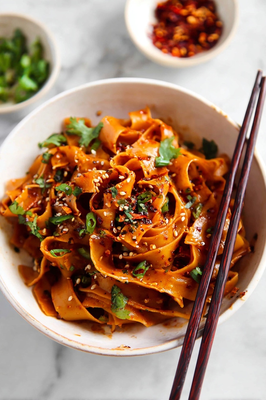 Spicy Chili Garlic Noodles, chili garlic noodle dish, spicy noodle recipe, quick Asian noodles, flavorful chili garlic stir-fry - The image shows a white pot filled with four layers of wide, flat noodles cooked in a dark brown sauce, giving the noodles a shiny and rich look. Scattered over the noodles are small pieces of green herbs and tiny bits of red chili pepper, adding a touch of color and texture. The noodles are swirled and mixed together with some areas appearing thicker and some thinner, showing a soft and smooth texture. The pot sits on a white marbled surface with a pair of dark brown chopsticks resting beside it. Nearby, there is a small white bowl filled with red chili flakes. Photo taken with an iphone --ar 2:3 --v 7