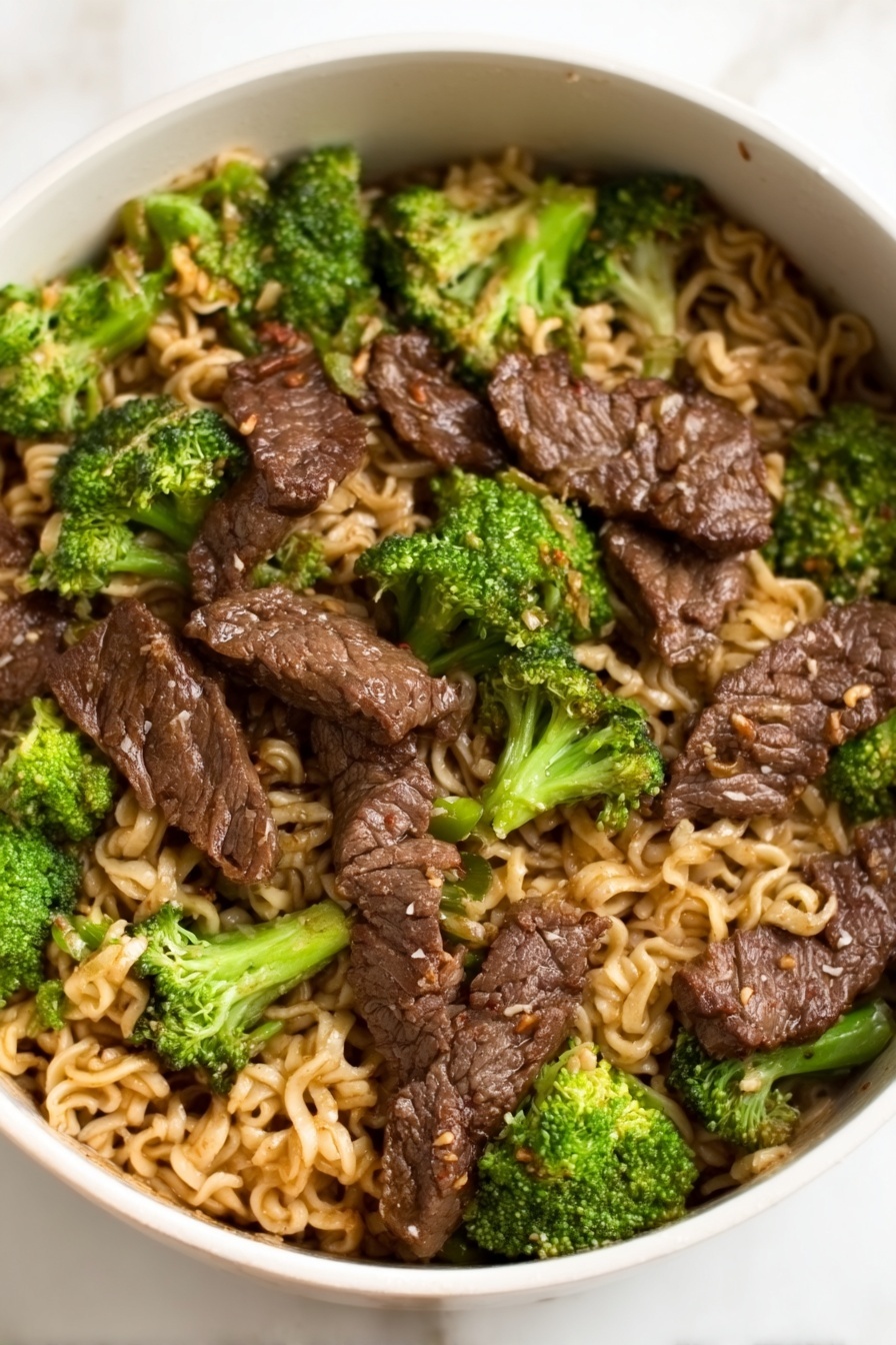 Beef Broccoli Ramen Stir-Fry, quick Asian stir-fry, easy beef ramen dinner, healthy noodle stir-fry, flavorful beef broccoli dish - A white bowl filled with a noodle dish topped with several pieces of dark brown cooked meat arranged evenly across the surface, mixed with bright green broccoli florets scattered throughout. The noodles underneath are light brown and slightly wavy, filling the entire bowl, with the meat and broccoli sitting on top. The glossy texture of the meat contrasts with the softer noodles and the fresh look of the broccoli, all placed on a white marbled surface. Photo taken with an iphone --ar 2:3 --v 7