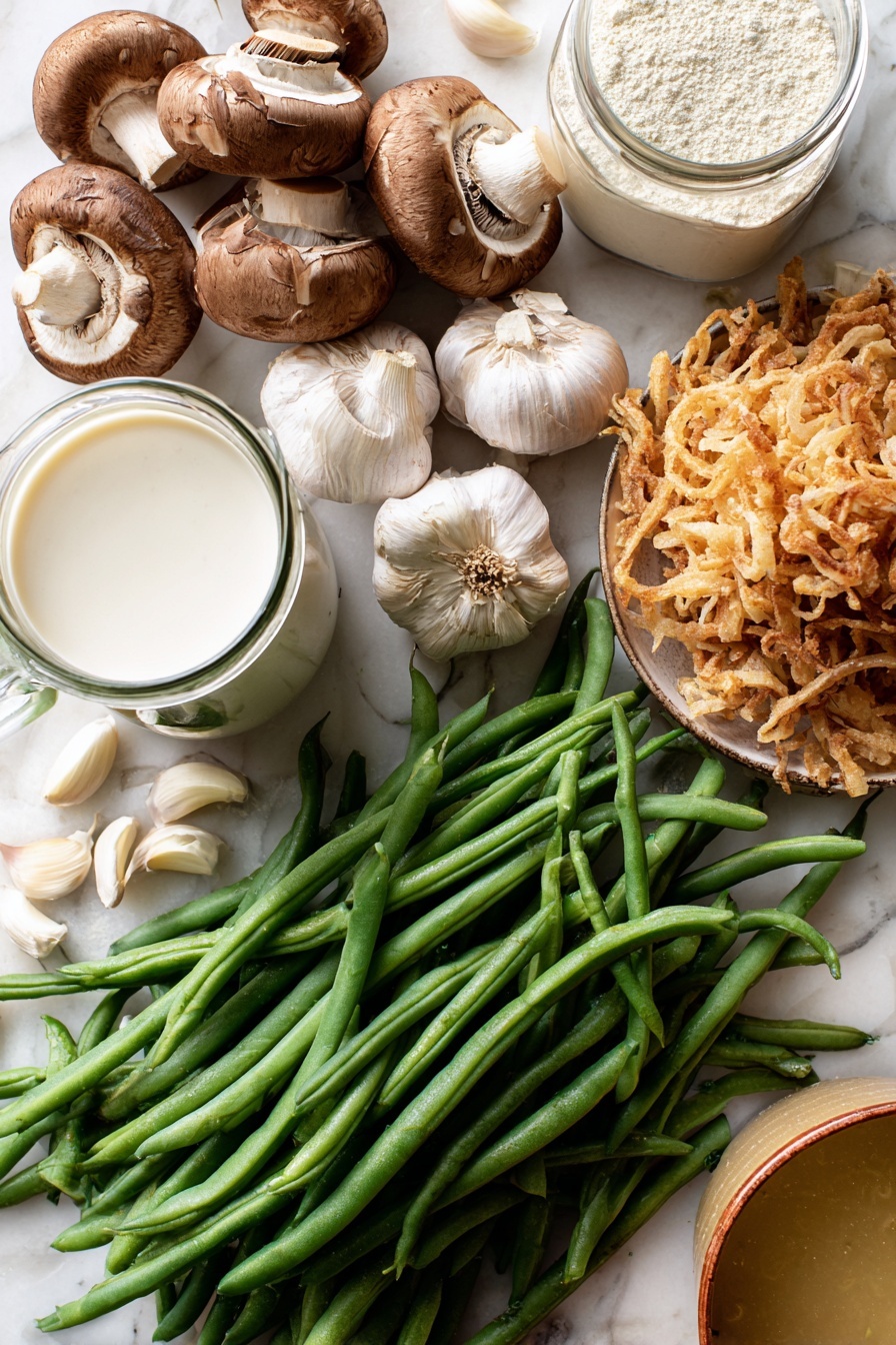 Vegan Green Bean Casserole, plant-based holiday casserole, vegan green bean dish, dairy-free green bean casserole, healthy vegan green bean recipe - Flat lay of fresh green beans with vibrant deep green hues, a cluster of earthy brown sliced mushrooms showing their soft texture, several plump garlic cloves with smooth off-white skin, a small mound of golden crispy french fried onions with a crunchy look, a glass jug of creamy white coconut-almond creamer, a clear container of pale beige raw flour, and a small bowl of rich golden vegetable broth, all naturally arranged with some beans and garlic cloves gently overlapping, placed on white marbled surface, photo taken with an iphone --ar 2:3 --v 7