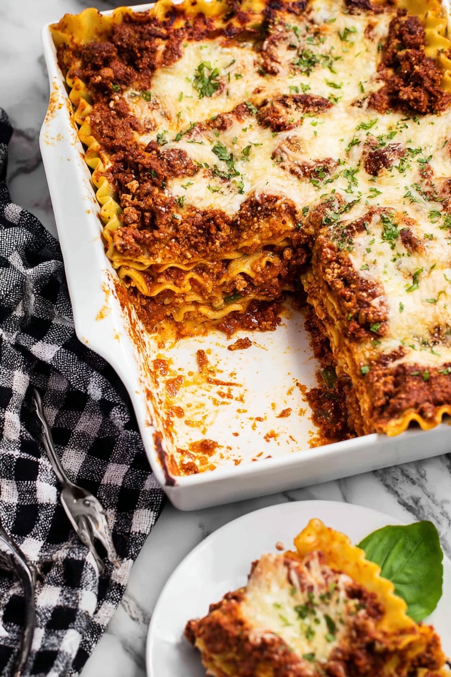 Hearty Bolognese Lasagna, best Bolognese lasagna, easy lasagna recipe, comfort food lasagna, layered pasta dish - A white rectangular dish filled with lasagna is shown, with one large piece taken out. The lasagna has several visible layers including a rich, dark red meat sauce, pale yellow pasta sheets with ruffled edges, and melted white cheese with a slightly browned top. The meat sauce layer appears thick and textured, while the cheese is spread unevenly and speckled with small green herb bits. A white plate on the side holds a small piece of lasagna, resting on a green leaf, with a silver fork nearby. The dish is placed on a white marbled surface with a black and white checkered cloth partially visible next to it. Photo taken with an iphone --ar 2:3 --v 7