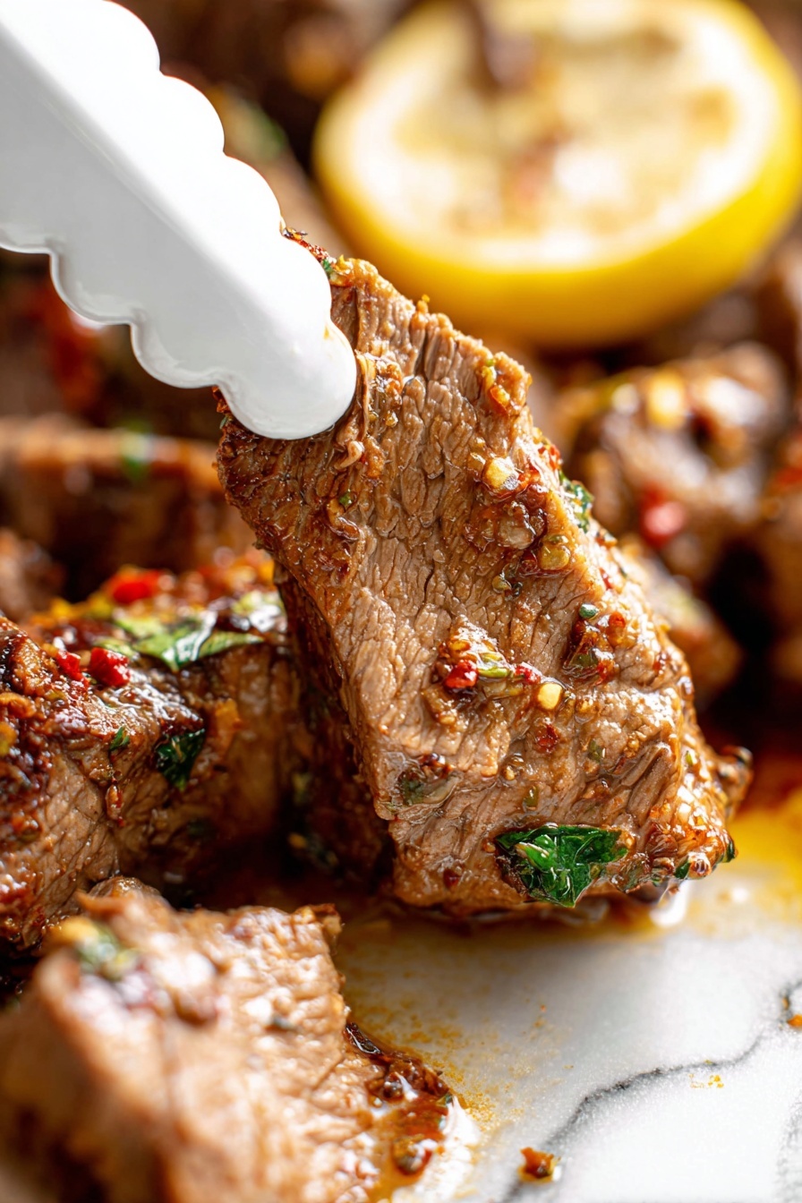 Slow Roasted Lamb Shoulder with Mint Sauce, lamb shoulder recipe, slow roast lamb, mint sauce recipe, tender lamb dinner - A close-up view of a piece of cooked meat being picked up by a white scalloped-edge tong, showing its tender texture with visible fibers and seasoning bits in red and green. The meat is brown with a moist surface, sitting next to a larger piece with the same texture, all on a white marbled surface. Behind the meat, there is a yellow lemon slice with some herbs on top, adding a pop of color. The scene is bright and focused on the meat’s juicy and spiced detail, photo taken with an iphone --ar 2:3 --v 7