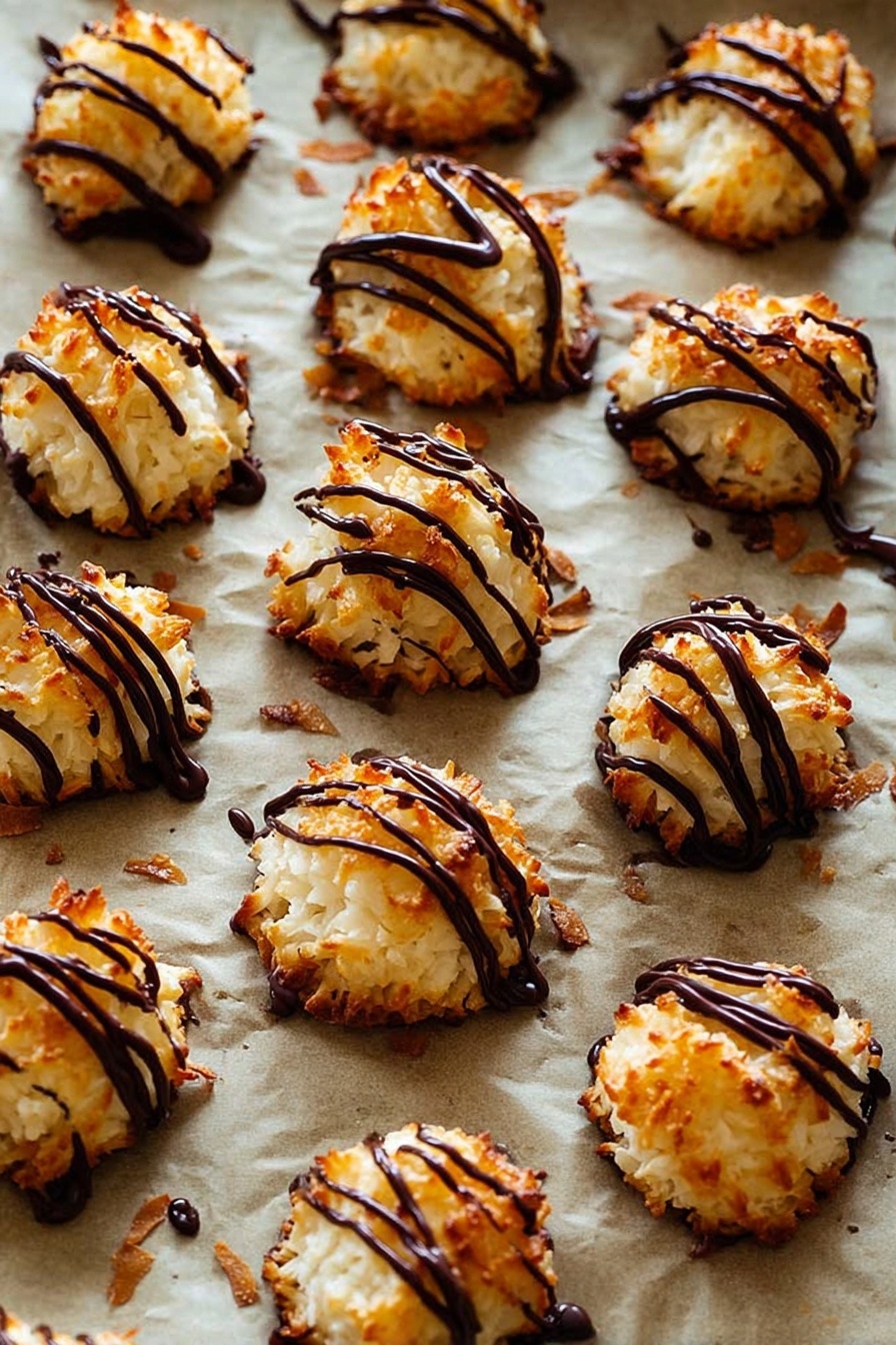 Chocolate Drizzled Coconut Macaroons, coconut macaroons with chocolate, chewy coconut cookies, easy coconut dessert, homemade coconut treats - The image shows many small, round coconut macaroons with a golden-brown, slightly crispy texture on the outside and white inside. Each macaroon is topped with thin, shiny dark chocolate drizzle in irregular lines, adding a rich contrast in color and glossy texture. These treats are placed on a baking sheet lined with parchment paper that has a light brown color, and some small browned coconut flakes are scattered around. The background is a white marbled texture. photo taken with an iphone --ar 2:3 --v 7