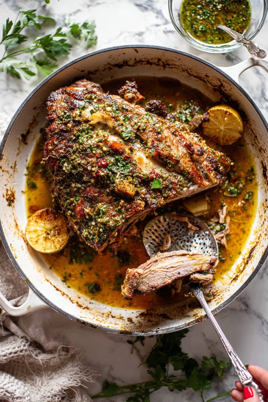 Slow Roasted Lamb Shoulder with Mint Sauce, lamb shoulder recipe, slow roast lamb, mint sauce recipe, tender lamb dinner - A large piece of roasted meat with a brown crispy herb crust on top sits in the center of a white cast iron pot. The meat has visible bone, and the herb crust includes green parsley and spices giving a textured, uneven surface. Underneath the meat, there is a golden-brown juicy sauce with visible slices of lemon and pieces of cooked onions. A metal fork held by a woman's hand is pulling apart a slice of the tender meat, revealing its soft inner texture. To the right inside the pot is a hammered metal spoon resting in the sauce. Around the pot, there are scattered fresh green herbs on a white marbled surface, and a small glass bowl with herb sauce is placed behind the pot. photo taken with an iphone --ar 2:3 --v 7