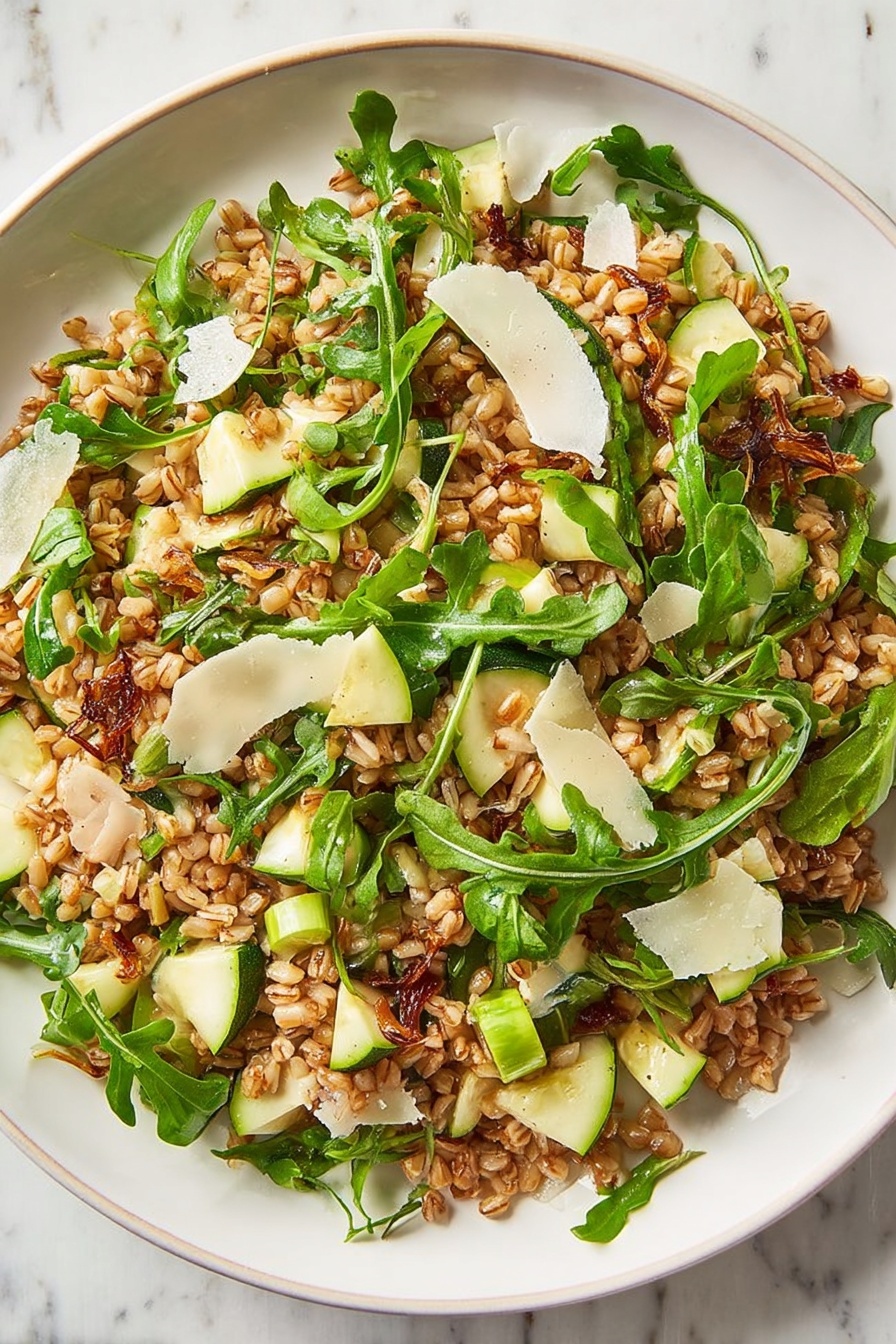 Farro Salad with Apple and Arugula, healthy farro salad, apple and arugula salad, easy grain salad, flavorful veggie salad - A clear glass bowl holds a mixed salad with three main layers: a bottom layer of cooked brown grains, a middle layer of bright green arugula leaves with thin stems, and a top layer scattered with thin white cheese shavings and small green apple pieces. The grains look slightly shiny, and the arugula adds a fresh, leafy texture. The bowl sits on a white marbled surface with two empty white bowls in the background. Photo taken with an iphone --ar 2:3 --v 7