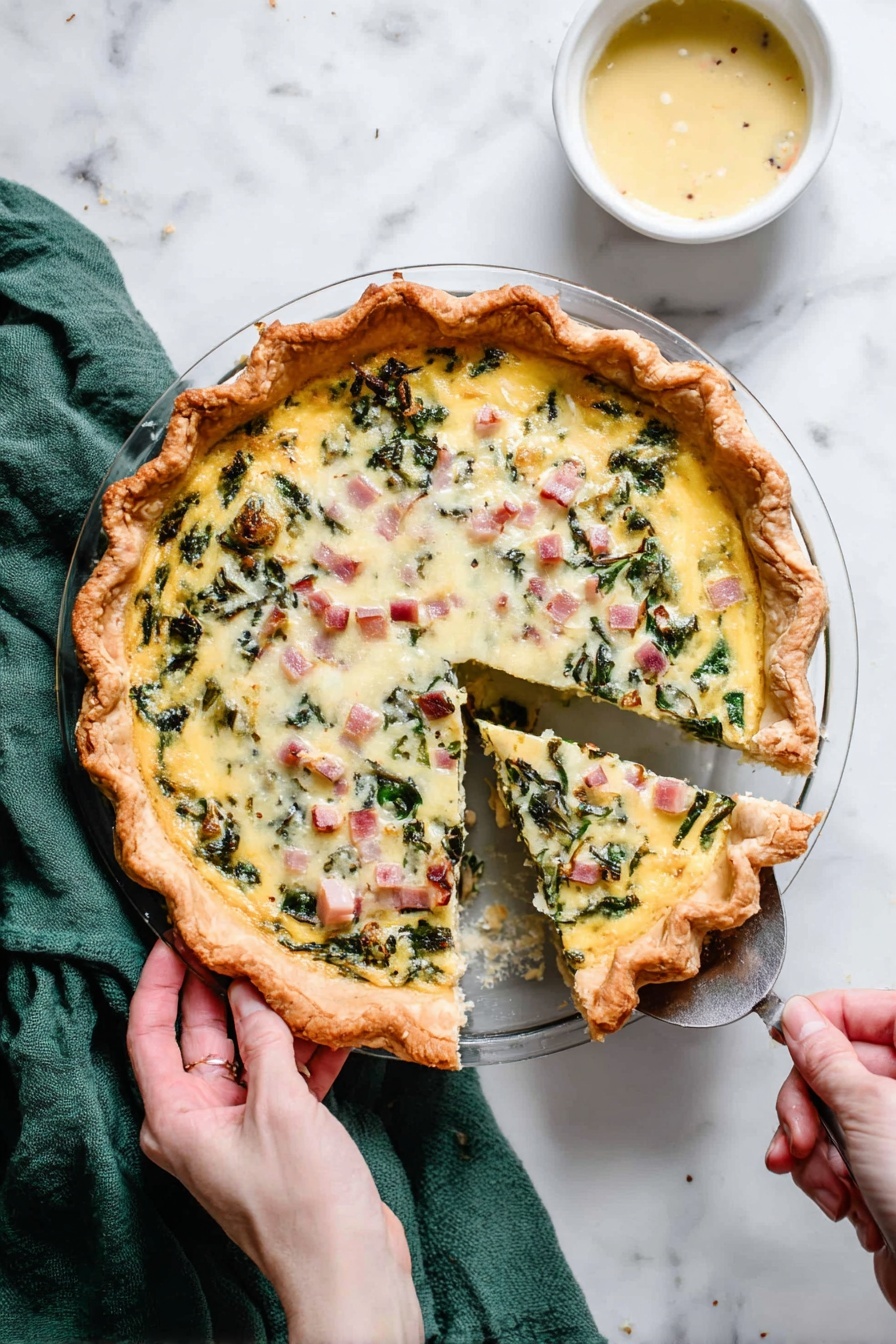 Cheese Quiche, savory pie recipe, easy cheese quiche, breakfast quiche, flaky crust quiche - A round pie with a thick golden brown crust holds a creamy egg mixture filled with green leafy vegetables and small cubes of pink ham, topped with melted white cheese and lightly browned spots. One slice is being lifted out with a silver spatula held by a woman's hand on the right, while another woman's hand holds the pie dish handle on the left. The pie sits on a white marbled surface with a green cloth partially visible at the top left and a small white bowl of light yellow sauce at the top right. Photo taken with an iphone --ar 2:3 --v 7
