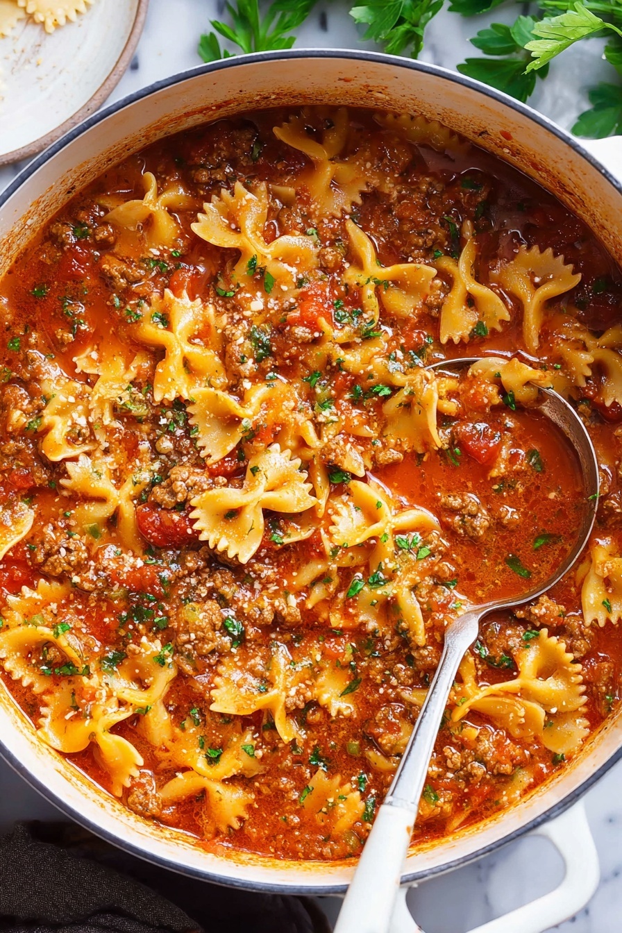 Lasagna Soup, Lasagna Soup with Pasta and Cheese, Easy Lasagna Soup Recipe, Comfort Food Dinner, Cozy Italian Soup - A large white pot filled with a thick stew made of bowtie pasta, ground meat, and rich red tomato sauce, garnished with small bits of green herbs on top; the sauce has a shiny, slightly oily surface with tomatoes and herbs visible throughout. A silver ladle with a white handle rests inside the pot, partially submerged in the stew. The background shows a white marbled surface with some green leaves and a white round dish partially visible on the side. photo taken with an iphone --ar 2:3 --v 7