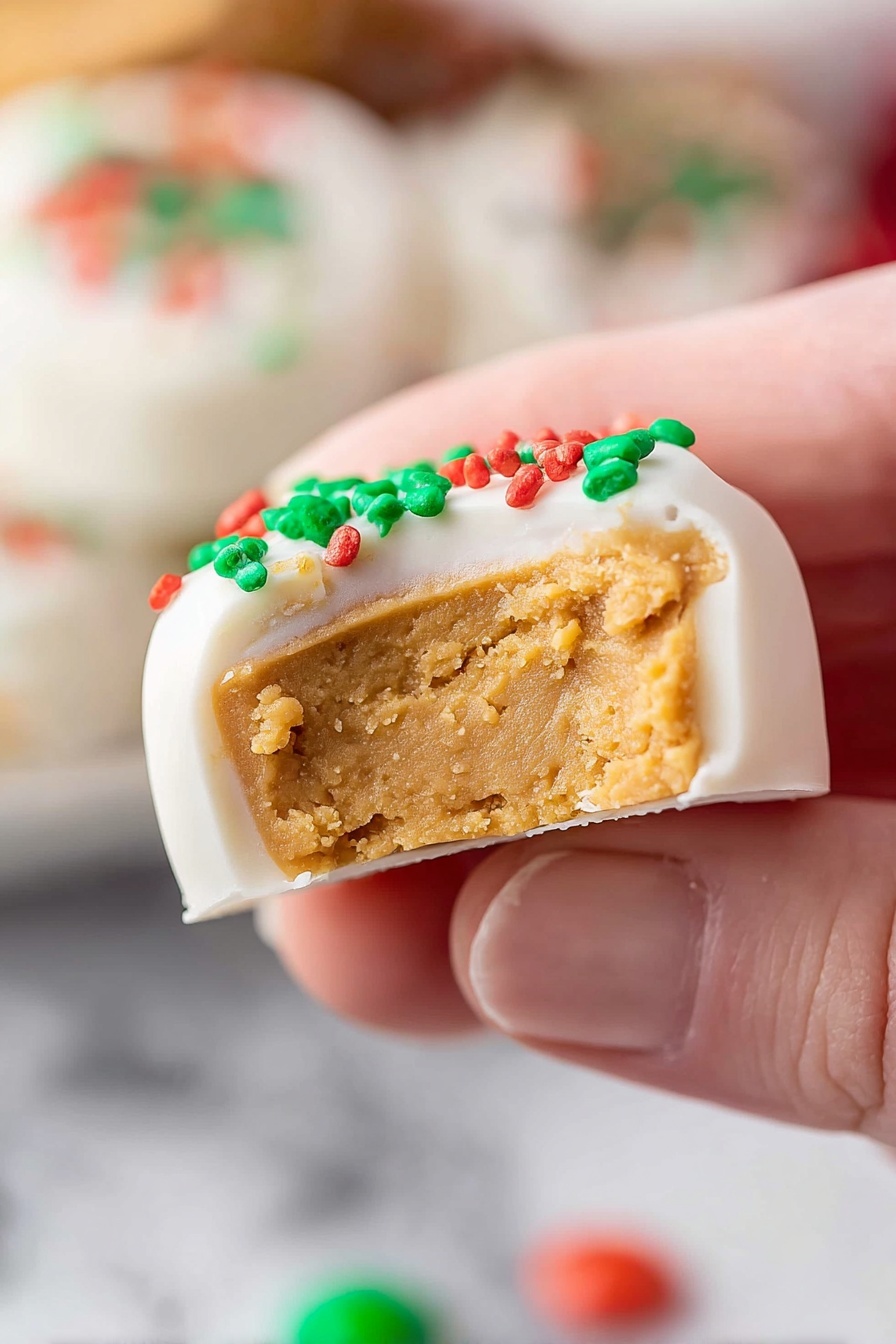 Homemade Peanut Butter Cups, easy peanut butter cups recipe, chocolate peanut butter treat, homemade candy recipes, no-bake peanut butter candies - A close-up view shows a piece of candy held by a person's fingers with the focus on the candy's interior layers. The candy has two layers: the thick bottom layer is soft and light brown, with a crumbly texture like peanut butter, while the top layer is smooth, white, and looks like a frosting coating with green and red small round sprinkles on top. The background shows blurred white marbled texture and more colorful candies in the distance, out of focus. Photo taken with an iphone --ar 2:3 --v 7