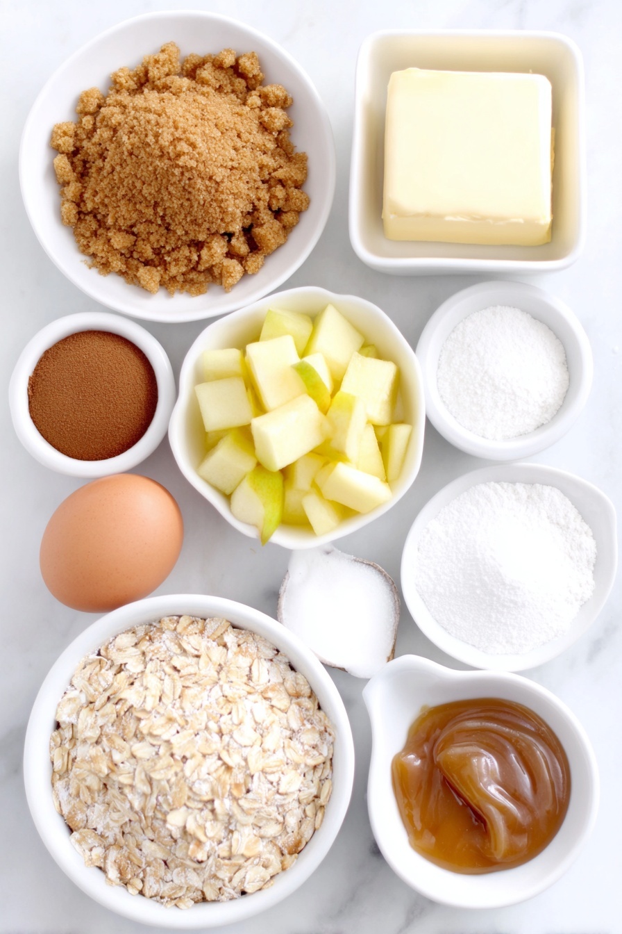 Apple Cheesecake Mini Cupcakes, fall dessert recipes, easy mini cupcake recipes, apple desserts, cheesecake cupcake recipes - Flat lay of a small pile of golden graham cracker crumbs, a neat mound of light brown sugar, a sprinkle of ground cinnamon in a small white bowl, a few curls of melted unsalted butter in a white ceramic dish, a small bowl of all-purpose flour, a heap of quick-cooking oats, a white ceramic bowl with a dusting of ground nutmeg, two medium-small peeled apples chopped finely, a small white ceramic bowl with freshly squeezed lemon juice, a block of soft cream cheese on a plain white plate, a clean whole brown egg, a small white bowl with granulated sugar, a small white bowl of vanilla extract, a small white bowl of cornstarch, and a white ceramic dish with golden caramel sauce placed on a clean white marble surface, soft natural light, photo taken with an iPhone, professional food photography style, fresh ingredients, white ceramic bowls, no bottles, no duplicates, no utensils, no packaging --ar 2:3 --v 7 --p m7354615311229779997