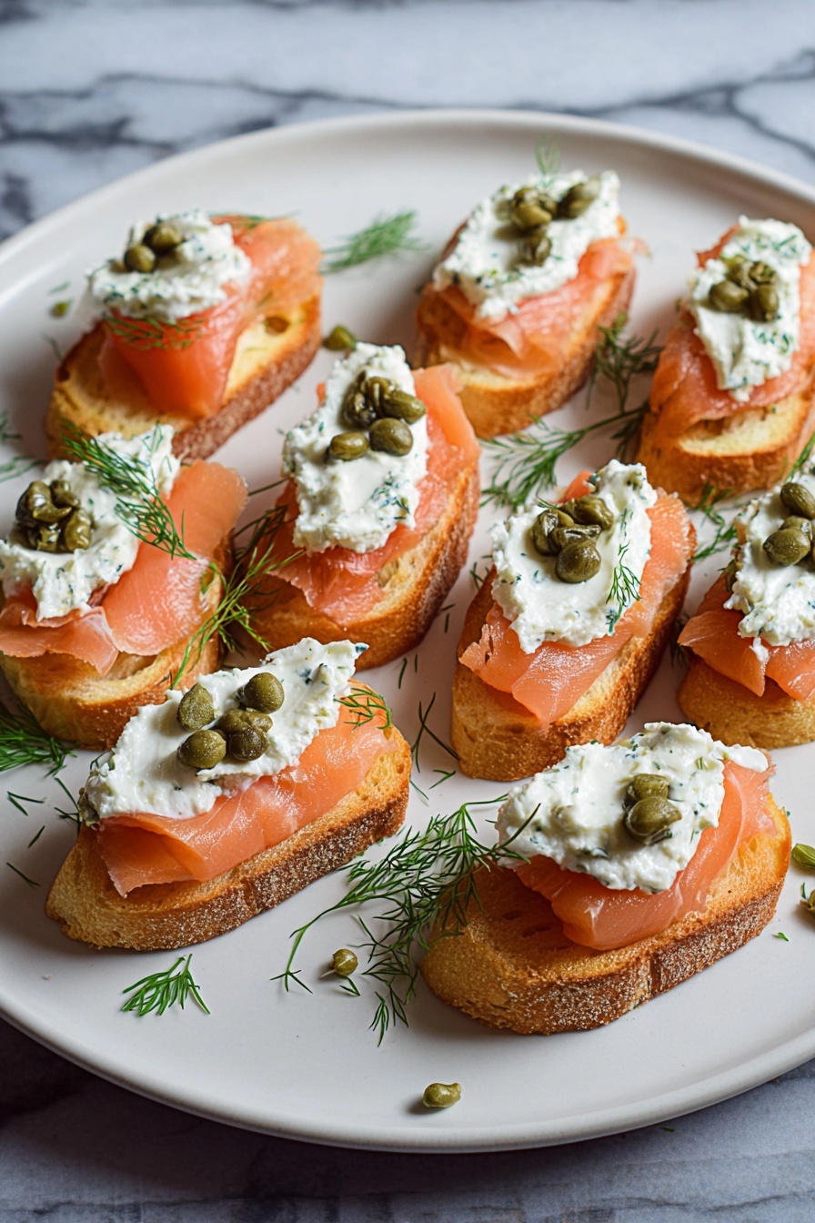 Smoked Salmon Crostini, smoked salmon appetizer, easy smoked salmon starters, elegant canapés, party appetizer ideas - The image shows a white plate with several small toasted bread slices arranged in rows. Each slice is topped with three layers: the bottom layer is pinkish-orange smoked salmon with a smooth texture, the middle layer is a dollop of white creamy spread mixed with herbs, and the top layer features a few small green capers and a small sprig of fresh green dill. The plate sits on a white marbled surface with some scattered dill and capers around the edges. photo taken with an iphone --ar 2:3 --v 7