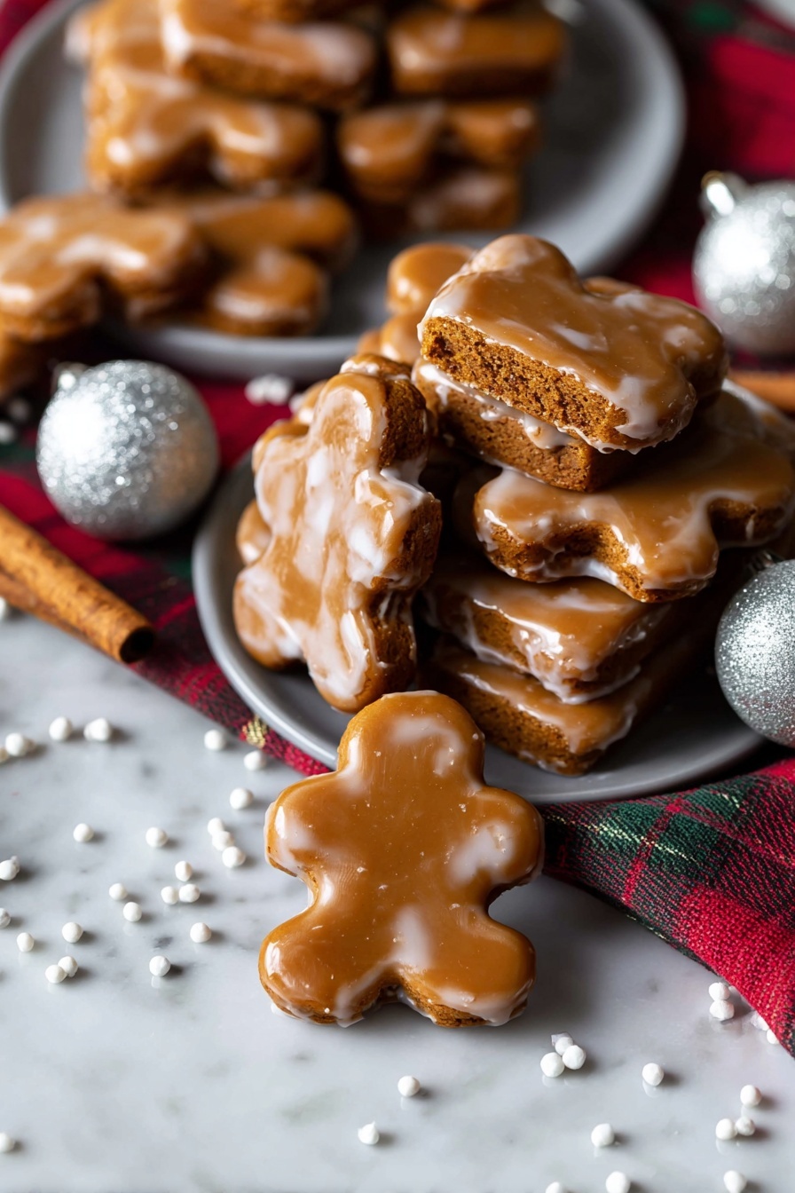 Chewy Gingerbread Man Cookies, gingerbread cookies, holiday baking recipes, chewy gingerbread treats, easy gingerbread cookies - A stack of seven rectangular gingerbread cookies covered in a shiny light brown icing is placed on a white marbled surface. On top, one cookie is broken in half to show the soft, slightly crumbly inside, which is a warm orange-brown color. The glaze has a smooth texture with a few small spots where it drips a little around the edges. The cookies are stacked unevenly, giving a casual, fresh-baked look with more cookies softly blurred in the background. photo taken with an iphone --ar 2:3 --v 7