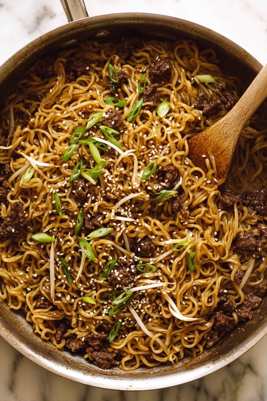 Asian Beef Ramen Noodles, quick beef ramen recipe, easy Asian noodle bowl, savory beef ramen, 15-minute ramen dinner - The image shows a metal pan filled with cooked noodles mixed with small pieces of dark brown meat and light bean sprouts. The noodles have a slightly shiny, brown color from the sauce. On top, there are sliced green onions and white sesame seeds scattered, adding texture and color contrast. A wooden spoon rests inside the pan, partially covered by the food. The pan sits on a white marbled surface. photo taken with an iphone --ar 2:3 --v 7