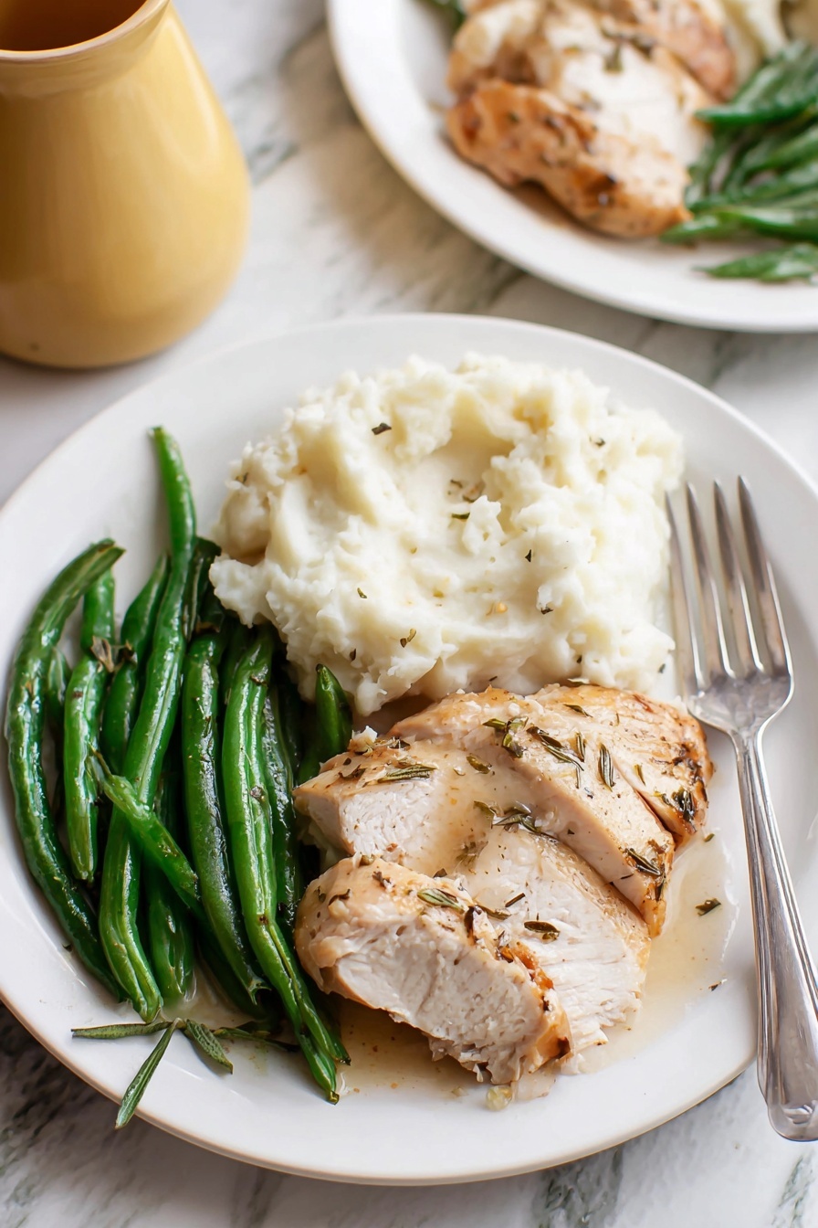 Easy Turkey Gravy, turkey gravy recipe, homemade turkey gravy, flavorful gravy, holiday turkey gravy - A white plate holds three main parts: on the left, green beans with a shiny, fresh texture; in the middle front, sliced cooked chicken with a light brown, slightly crispy skin and some herb seasoning; on the right, a large scoop of white mashed potatoes with a soft, fluffy texture, and a silver fork resting at the edge of the plate. The plate sits on a white marbled surface, with a blurred second plate in the back and part of a yellow jug visible. photo taken with an iphone --ar 2:3 --v 7