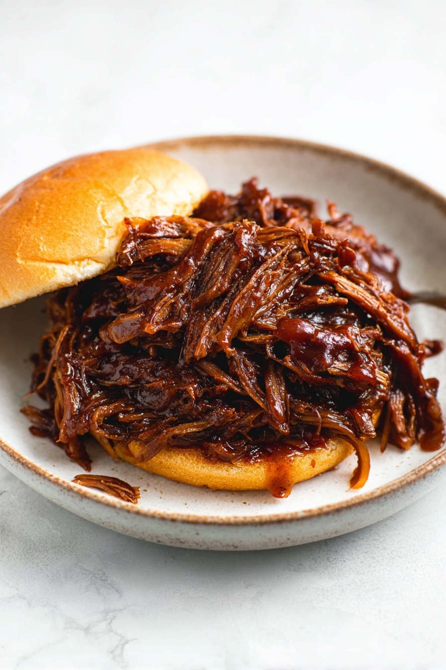 Slow Cooker Honey BBQ Beef Brisket, Honey BBQ Beef Brisket, Slow Cooker Brisket Recipe, Tender BBQ Beef, Easy Brisket Dinner - A sandwich on a soft, shiny light brown bun with two layers: the bottom bun and the top bun. Between them is a large pile of dark brown shredded meat covered in thick, shiny barbecue sauce that drips slightly onto the white marbled surface and around the sandwich. The sandwich sits on a white plate with a soft black color and a slightly glossy texture, and the background is a white marbled texture. photo taken with an iphone --ar 2:3 --v 7