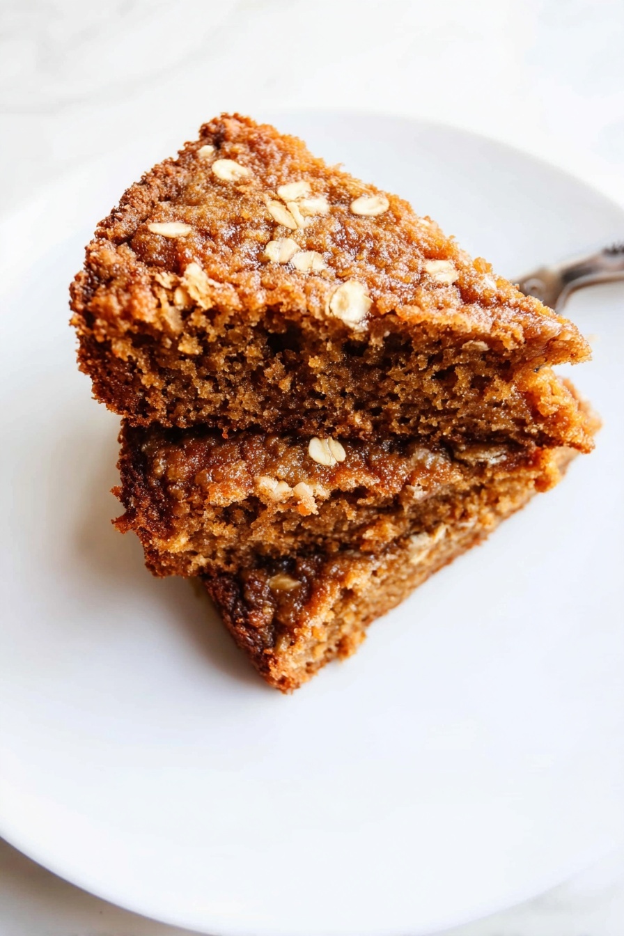 Healthy Apple Oatmeal Cake, healthy breakfast cake, gluten-free apple cake, wholesome oatmeal cake, easy apple oatmeal dessert - The image shows three brown, textured snack bars stacked on top of each other on a white marbled surface. Each bar looks soft and moist inside with a rough, slightly crispy outer layer. The bars have an uneven, crumbly texture with small visible bits that suggest oats or nuts, and their edges appear slightly jagged. The lighting highlights the bars’ warm color and their dense, chewy appearance. Photo taken with an iphone --ar 2:3 --v 7