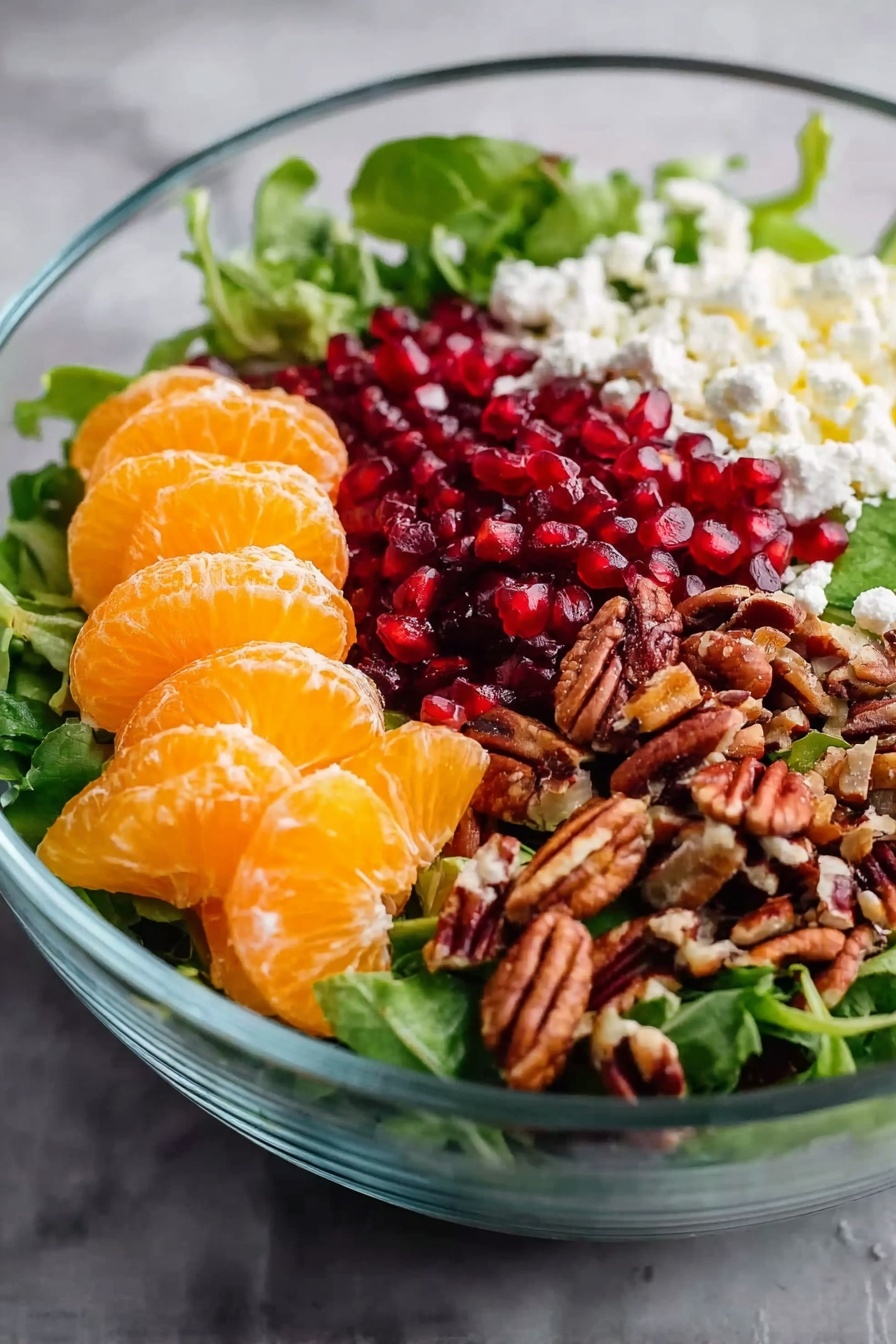 Winter Salad with Citrus and Pomegranate, citrus winter salad, pomegranate salad recipe, healthy winter salad, easy citrus salad - A clear glass bowl holding a fresh salad on a white marbled surface, with a base layer of mixed green leaves. On one side are bright orange segments of peeled mandarins, stacked together. Next to the mandarins, crumbled white cheese is placed, adding a soft texture. Beside the cheese, there is a pile of small, glossy red pomegranate seeds. On the last side, a heap of chopped brown pecans adds a crunchy contrast. Photo taken with an iphone --ar 2:3 --v 7