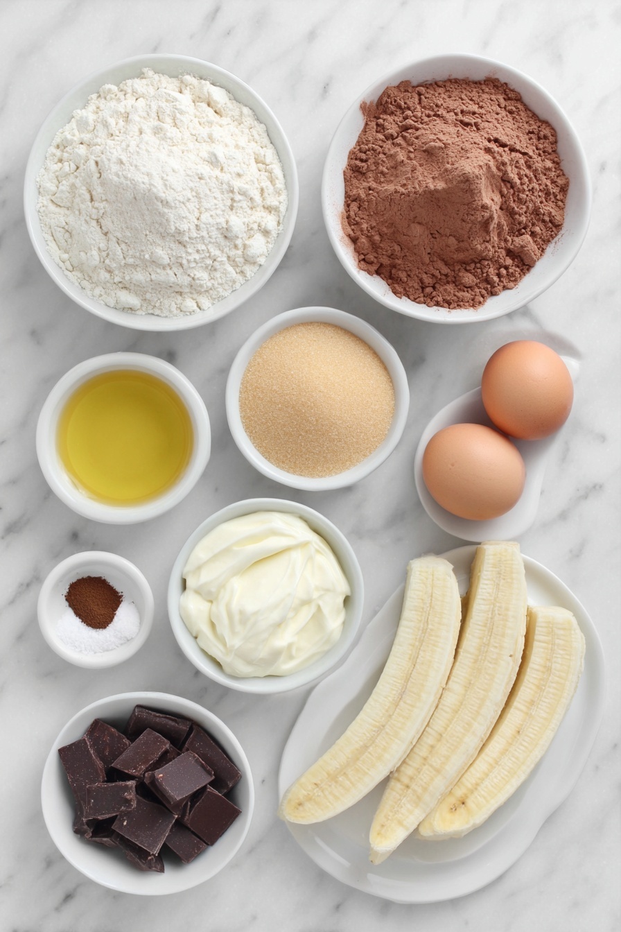 Chocolate Espresso Banana Bread, chocolate banana bread with espresso, moist banana bread with chocolate and espresso, easy chocolate banana loaf, decadent banana bread recipes - Flat lay of a small mound of all purpose flour, a small mound of cocoa powder, a teaspoon of fine espresso powder, a teaspoon of kosher salt, a teaspoon of baking soda, a small white bowl of golden olive oil, a small white bowl filled with light brown granulated sugar and another small white bowl with white granulated sugar, two whole uncracked brown eggs with clean shells, a small white bowl of sour cream, a small plate with three ripe peeled bananas, a small white bowl with dark chocolate chips, another small white bowl with semi sweet chocolate chips, two long thin banana slices on a simple white ceramic plate arranged neatly beside the bowls, all ingredients arranged symmetrically and proportionally, placed on a clean white marble surface, soft natural light, photo taken with an iPhone, professional food photography style, fresh ingredients, white ceramic bowls, no bottles, no duplicates, no utensils, no packaging --ar 2:3 --v 7 --p m7354615311229779997