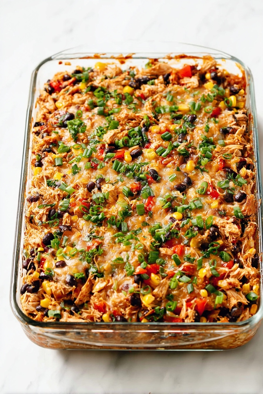 Easy Chicken Burrito Casserole, chicken burrito casserole, stovetop chicken casserole, easy dinner ideas, weeknight casserole recipes - A clear glass rectangular dish filled with a baked casserole made of multiple layers mixed together, showing shredded chicken pieces in light brown, black beans scattered throughout, small bright yellow corn kernels, red diced peppers, and bits of melted cheese that lightly covers the top layer. Chopped fresh green herbs and sliced green onions are sprinkled evenly across the surface, adding a vibrant green contrast to the warm colors of the casserole. The dish is placed on a white marbled surface, with some browned edges visible where the casserole touched the glass. photo taken with an iphone --ar 2:3 --v 7