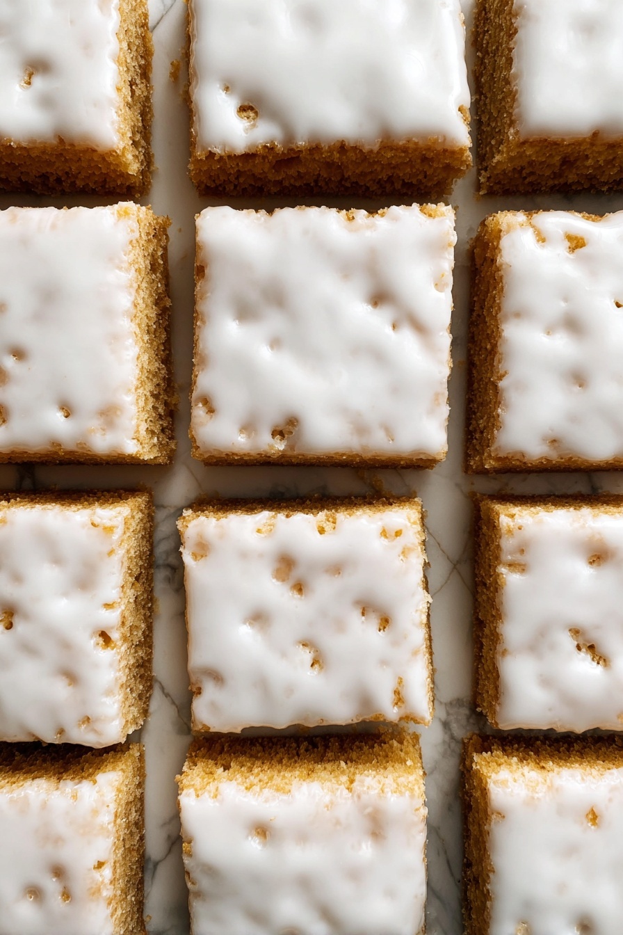 Iced Oatmeal Cookie Bars, oatmeal cookie bars, cinnamon dessert bars, vanilla glazed cookie bars, no-bake oat bars - The image shows nine square pieces of a light brown cake arranged in a 3x3 grid on a white marbled surface. Each piece is thick and topped with a smooth, glossy white icing that covers the entire top layer but is slightly uneven, with some small holes and cracks revealing the cake underneath. The edges between the squares are cleanly cut, showing the dense texture of the cake layers below the shiny icing. photo taken with an iphone --ar 2:3 --v 7