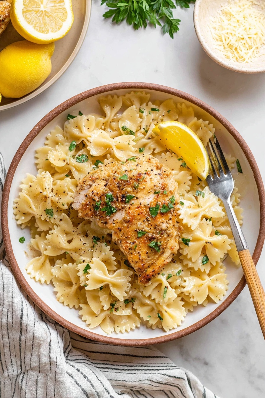 Lemon Chicken Pasta, lemon chicken pasta recipe, easy lemon chicken pasta, quick pasta with lemon and chicken, flavorful lemon chicken dinner - A round white plate with a brown rim holds a serving of farfalle pasta layered evenly on the bottom, showing a light creamy-yellow color with a slight shine. On top of the pasta lies a golden-brown cooked chicken piece, slightly crisp on the outside, garnished with small green parsley leaves and black pepper flakes. A small lemon wedge sits on the chicken, adding a bright yellow contrast. A fork with a light wooden handle rests on the right side of the plate, tipped slightly into the pasta. The setting is on a white marbled surface with part of a striped cloth visible at the bottom, a beige plate holding a lemon and parsley partly seen in the top left, and a white bowl with grated cheese in the top right. photo taken with an iphone --ar 2:3 --v 7